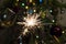 Burning Sparkler fire amid Christmas tree lights