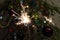 Burning Sparkler fire amid Christmas tree lights