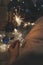 Burning sparkler in woman hand in lush tulle dress. Gifts, holiday decor, champagne bottle and glass blurred onbackground,