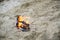 Burning sports sneakers or gym shoes on fire stand on sandy beach coast. Athlete burned out. Physical exertion during training