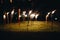 Burning torches at night in the grass with yellow flames and highlights