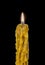 Burning vintage church candle wax close-up on a brilliant black background.