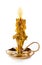 Burning vintage church candle wax in old gold candlestick on white background.