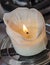Burning white candle, melted wax, close up flame
