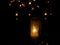 Burning white and colourful candles on a cemetery at night of all the saints, orange lights.