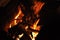 Burning wood campfire in the night darkness. Firewood bonfire is blazing. Abstract blurred flame background. Fiery backdrop.