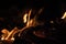 Burning wood at night. Campfire at touristic camp at nature in mountains. Flame amd fire sparks on dark abstract