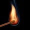 Burning wooden match on a black background