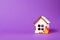 burning wooden model of a house, fire cut out of felt, purple background copy space