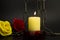 Burning yellow candle, chain and two roses