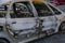 Burnt car`s door in the street close-up. Riot, civil protest, hooliganism, criminal in the city. Explosion, fire result. Car insur
