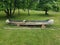 Burnt log canoe on green grass or lawn