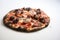 Burnt pizza dough with cheese, sausage and tomatoes in smoke on a white background.