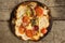 Burnt pizza with tomatoes, salami,pepperoni on wooden rustic background