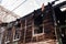 Burnt wooden rural house house, black charred walls