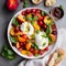 Burrata cheese salad with peaches, tomatoes, cranberries and basil on a gray background. Close up, top view. Healthy diet food