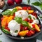 Burrata cheese salad with peaches, tomatoes, cranberries and basil on a light gray background. Close up. Healthy diet food concept