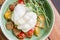 Burrata salad with cherry tomatoes, pesto and spices in a bowl
