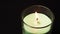 Burring aroma candle on black background close up. Wooden stick lights candle, filmed on high framerate. Ignition of aroma candle