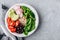 Burrito Buddha Bowl with wild rice and broccoli, spinach, black beans, tomatoes, avocado and radish