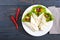 Burrito with chopped meat, avocado, vegetables, hot pepper on a plate on a dark wooden background.