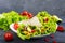 Burrito with chopped meat, avocado, vegetables, hot pepper on a plate on a dark wooden background.
