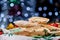 Burrito with meat and vegetables on a wooden board and napkins against a blue blurred beautiful garland