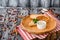 Burrito with vegetables, decorated with soy sprouts, served with cream sauce, on wooden plate on gray wooden background