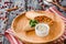 Burrito with vegetables, decorated with soy sprouts, served with cream sauce, on wooden plate on gray wooden background