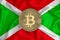 Burundi flag, bitcoin gold coin on flag background. The concept of blockchain, bitcoin, currency decentralization in the country.