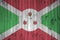 Burundi flag depicted in bright paint colors on old wooden wall. Textured banner on rough background