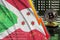 Burundi flag and falling red arrow on bitcoin mining screen and two physical golden bitcoins