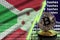 Burundi flag and rising green arrow on bitcoin mining screen and two physical golden bitcoins