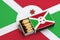 Burundi flag is shown in an open matchbox, which is filled with matches and lies on a large flag