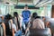 A bus crew in uniform and a hat smiling while briefs the passengers