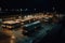 bus depot at night, with buses parked in rows and their headlights shining