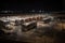 bus depot at night, with buses and vehicles parked in the bays