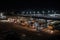 bus depot at night, with the lights shining and vehicles in motion