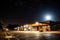 bus depot at night, with the moon shining above and stars twinkling in the sky