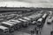 bus depot during rush hour, with lines of buses and passengers waiting to board