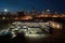 bus depot with view of bustling city skyline at night, with bright lights shining