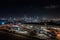 bus depot with view of the city skyline at night, featuring bright and vibrant lights