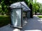 Bus shelter at a bus stop of glass and aluminum structure in park like setting