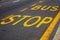 Bus stop sign with yellow paint on the asphalt. A symbol of expectation, rethinking the meaning of life, the final path, the road