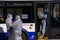 Bus workers wearing protective costumes and face protective masks waiting for passengers at arrival at Riga International Airport