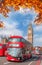 Buses with autumn leaves against Big Ben in London, England, UK