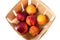 A bushel basket full of fresh picked yellow peaches, view from above