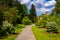 Bushes and trees along a path and the Cylburn Mansion at Cylburn Arboretum, Baltimore, Maryland.