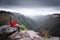 Bushwalker admires winterviews mountain wilderness as fog and cl