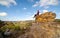 A bushwalker sits high atop a landscape of pagodas, valleys, gullies and canyons